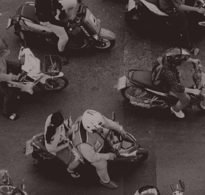 aerial black and white photo of people driving past on motorbikes
