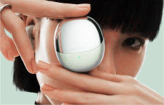 close up of a woman holding a round perfume bottle in her hands