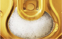 close up of an open can of beer with foam