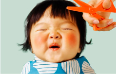 a child making a shocked face with eyes closed about to have their hair cut